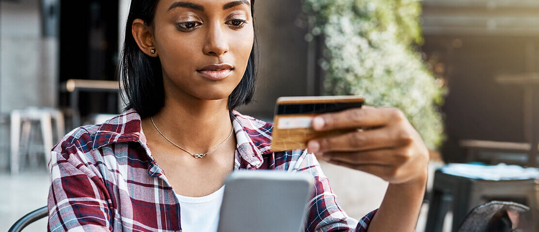 Woman holding mobile phone and credit card